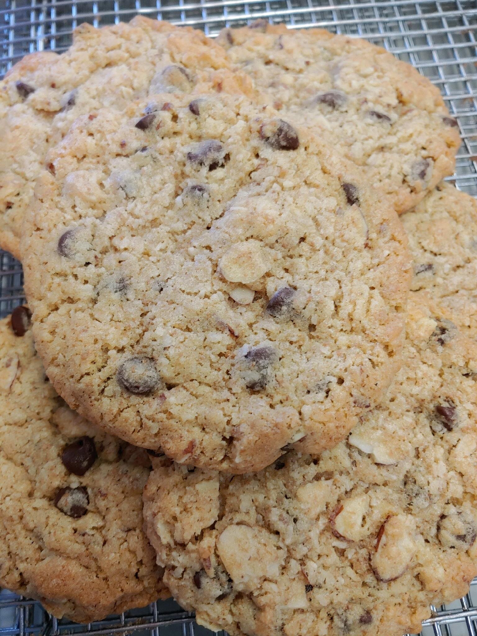 Freshly baked chocolate chip cookies stacked on a cooling rack, showcasing a golden-brown color and a chewy texture. Perfect for dessert or a sweet snack.